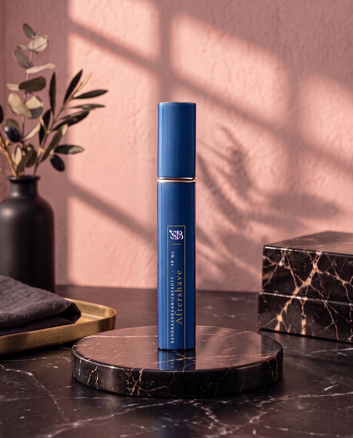 A slim navy blue aftershave spray with a gold label on a black marble stand